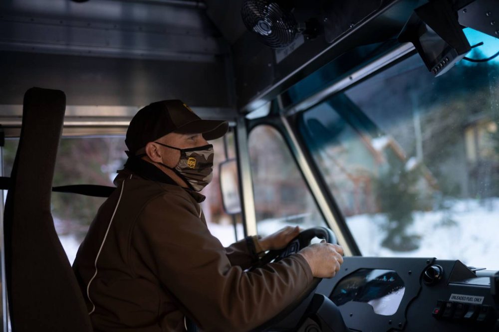 UPS driver wearing branded surgical mask and driving truck