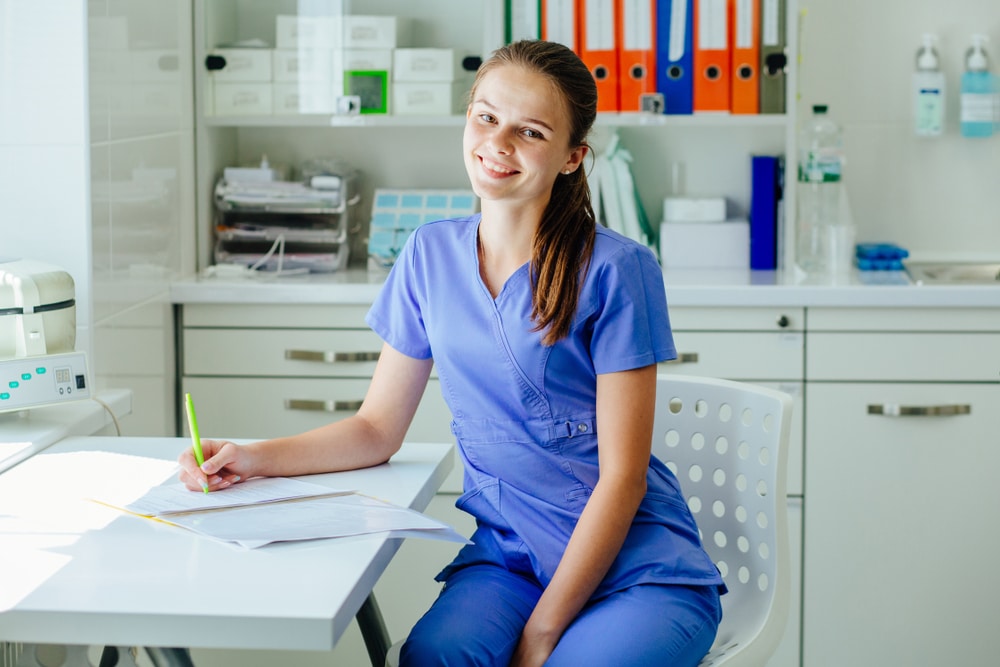 Smiling medical assistant with equipment